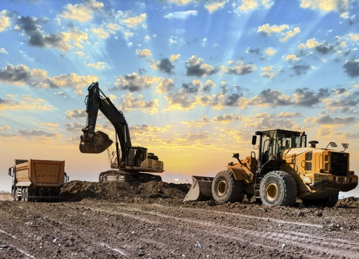 Excavator pushing dirt at a construction site.
