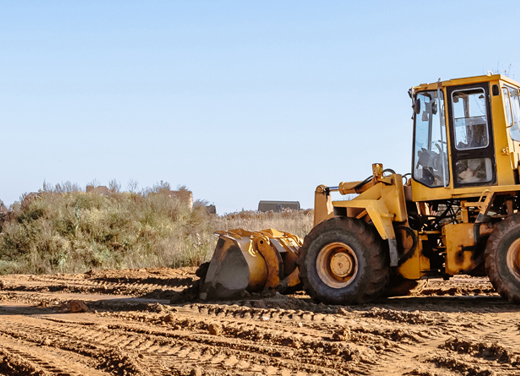 Excavator pushing dirt at a job site.