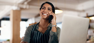 Woman talking on a cellphone, smiling.