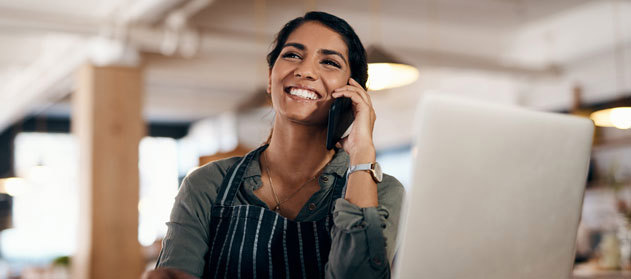 Woman talking on a cellphone, smiling.