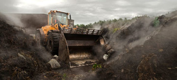 Excavator moving a pile of earth.