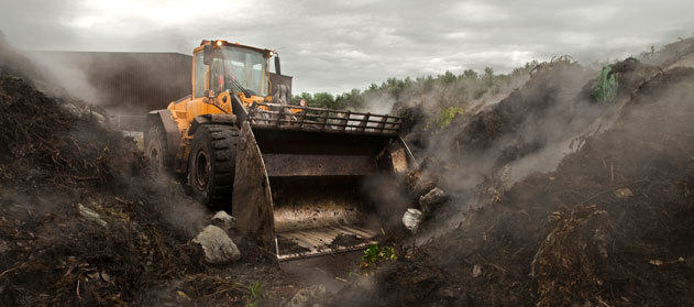 Excavator moving a pile of earth.